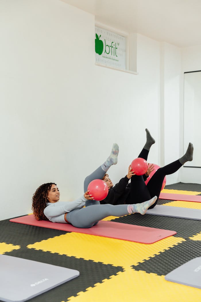 Women Exercising with Pink Balls at Gym